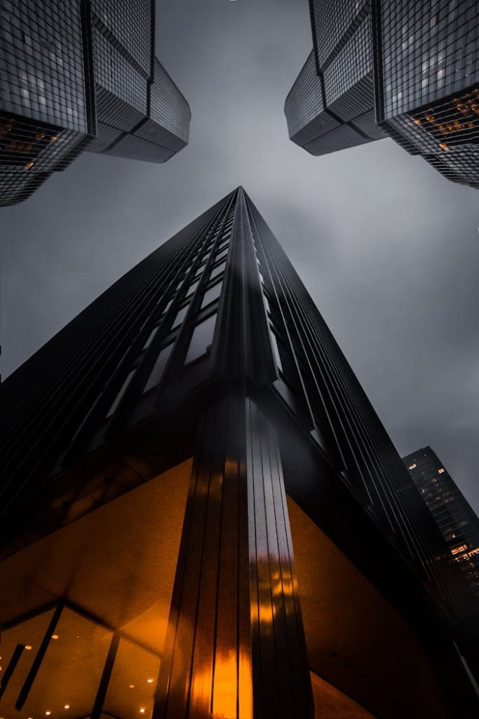 pexels-photo-1707823 A low angle view of skyscrapers reaching into a moody night sky, showcasing modern architecture.