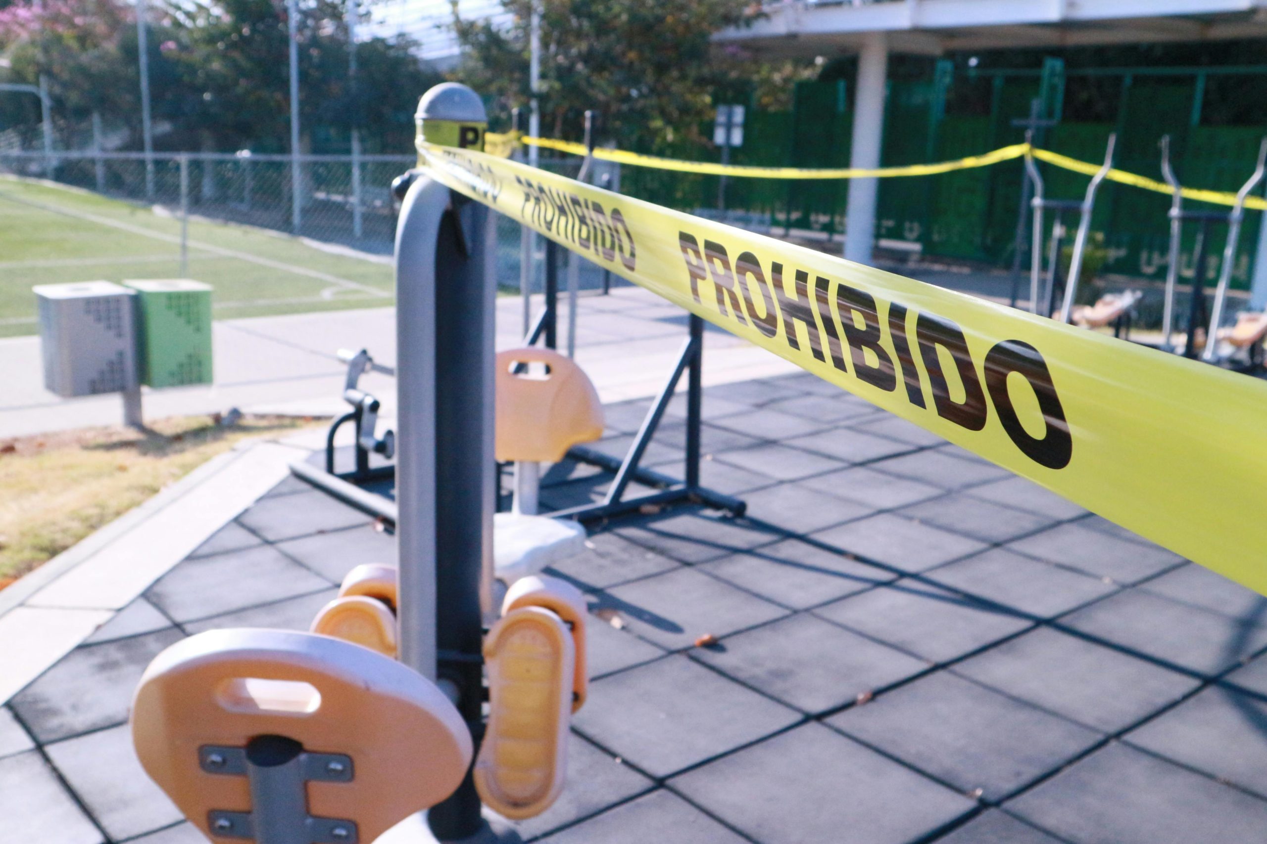 Yellow caution tape blocks access to outdoor gym equipment in Oaxaca, Mexico.